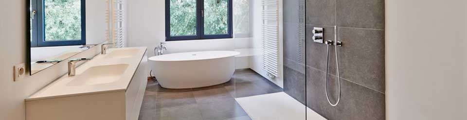 Bad mit freistehender Wanne, bodentiefer Dusche, Wandheizkörper und einer Doppelwaschtischanlage mit Unterschrank